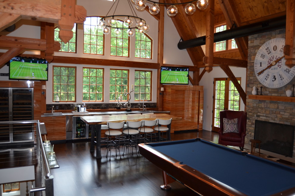 This is an example of a large contemporary enclosed family room in New York with a game room, white walls, dark hardwood floors, a standard fireplace, a stone fireplace surround, a freestanding tv and brown floor.