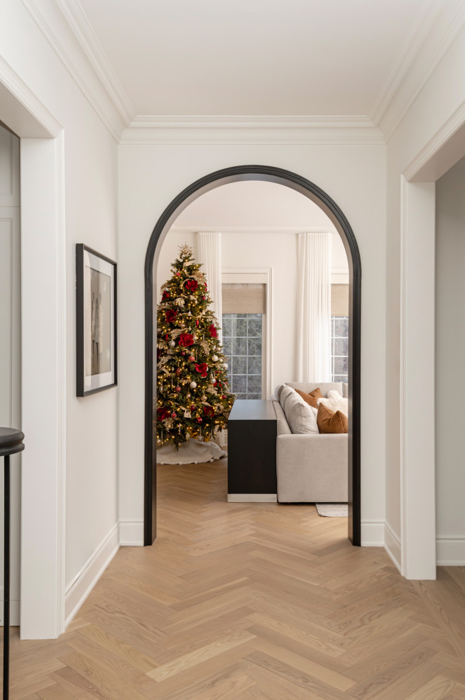 Mid-sized transitional medium tone wood floor hallway photo in Toronto with white walls