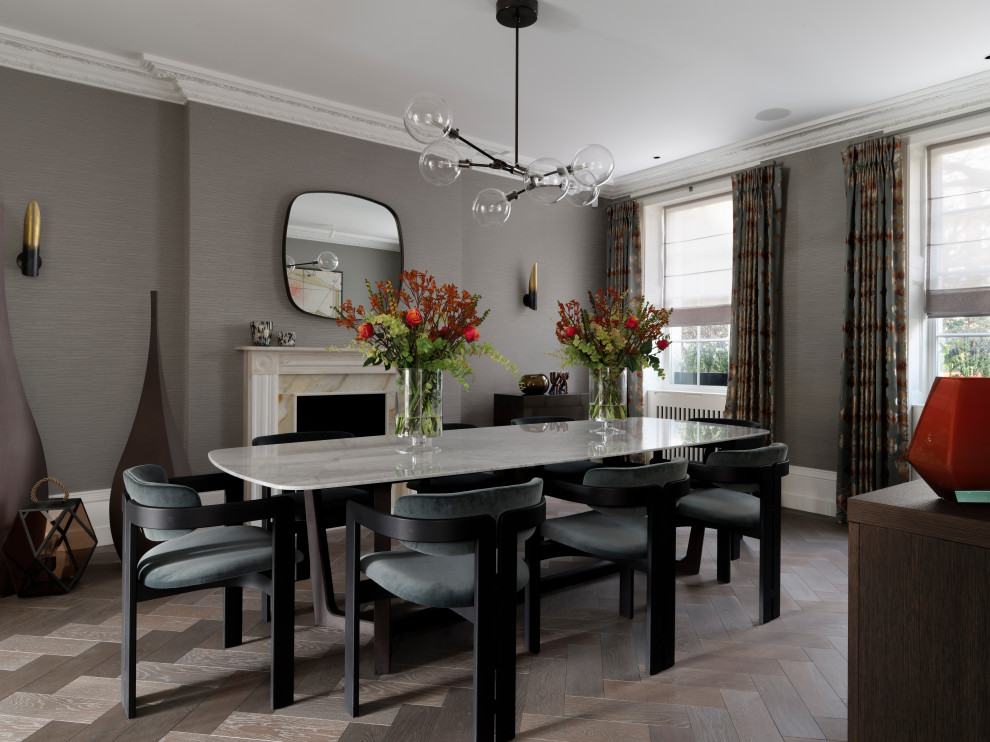 Design ideas for a large contemporary separate dining room in London with grey walls, medium hardwood floors, a standard fireplace, a stone fireplace surround, grey floor and wallpaper.