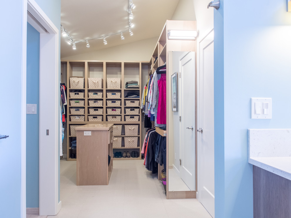 Inspiration for a mid-sized transitional gender-neutral walk-in wardrobe in Seattle with flat-panel cabinets, grey cabinets, ceramic floors, beige floor and vaulted.