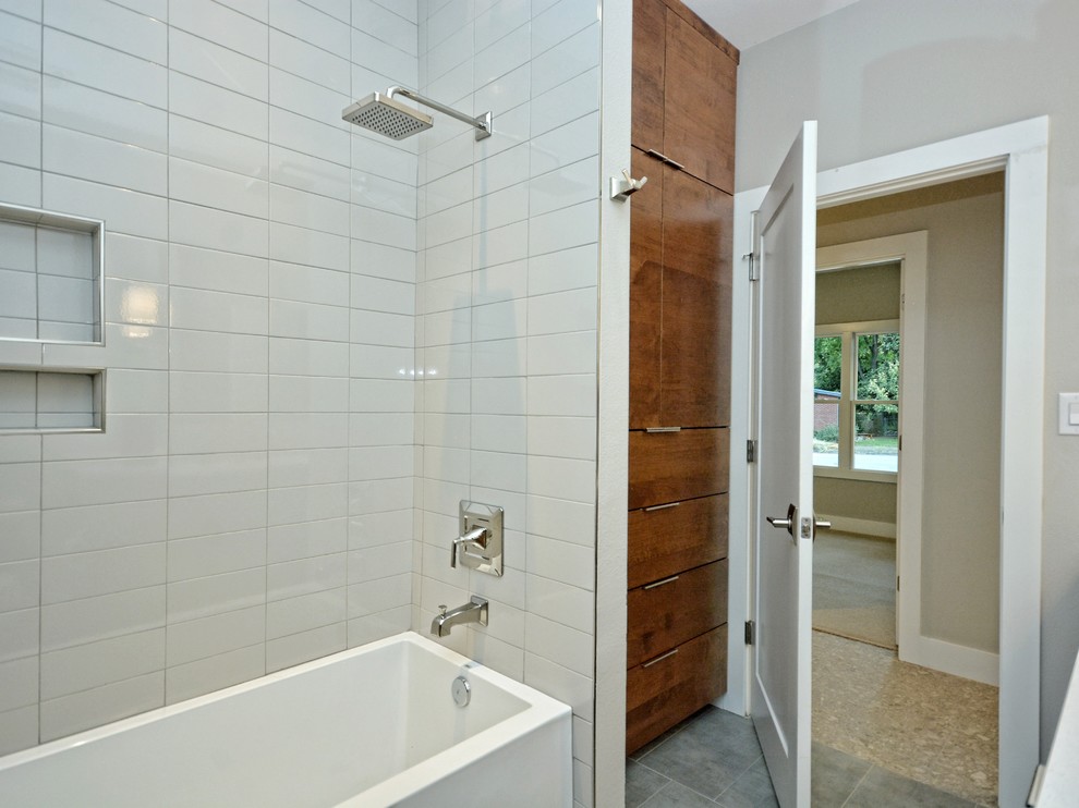 This is an example of a large midcentury master bathroom in Austin with flat-panel cabinets, medium wood cabinets, a drop-in tub, a double shower, gray tile, subway tile, grey walls, travertine floors, an undermount sink and quartzite benchtops.