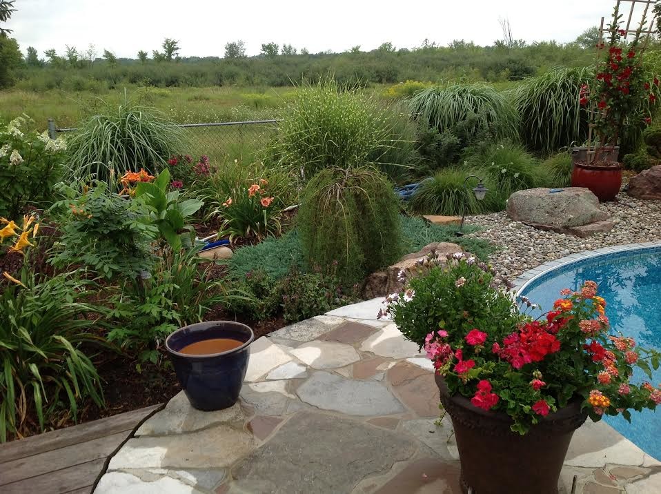 Inspiration for a large transitional backyard stone landscaping in Ottawa.