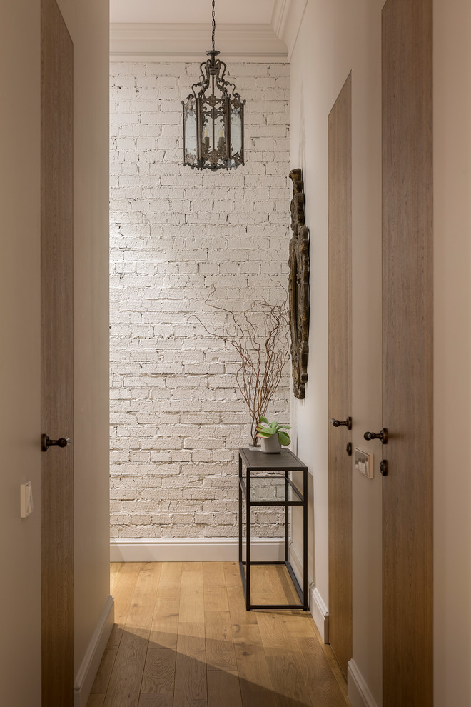 Design ideas for a transitional hallway in Moscow with white walls, medium hardwood floors and brown floor.