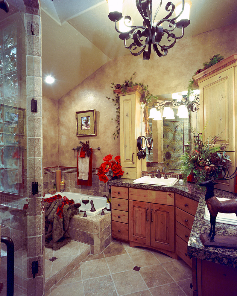 Large country master bathroom in Denver with a drop-in sink, raised-panel cabinets, distressed cabinets, granite benchtops, a drop-in tub, an alcove shower, brown tile, ceramic tile, brown walls and ceramic floors.
