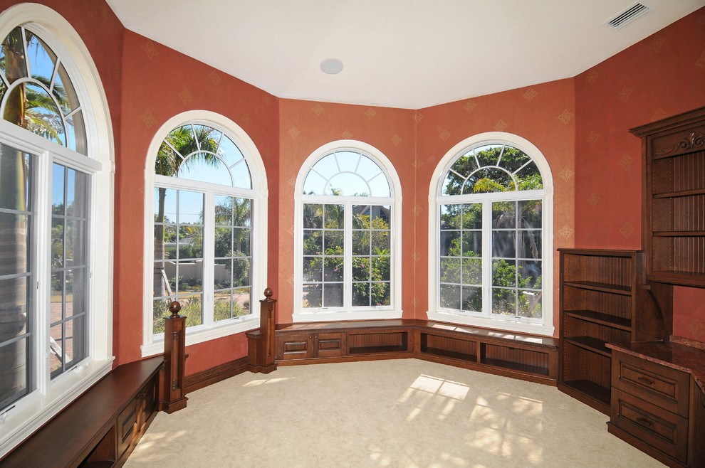 Design ideas for a mid-sized mediterranean study room in Tampa with ceramic floors, a built-in desk and orange walls.