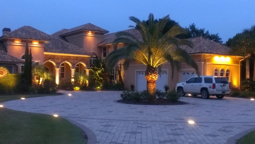Photo of a large tropical front yard full sun driveway for summer in Orlando with a garden path and brick pavers.