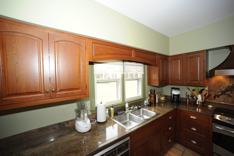 Enclosed kitchen - mid-sized transitional u-shaped limestone floor enclosed kitchen idea in Baltimore with an undermount sink, beaded inset cabinets, dark wood cabinets, granite countertops, beige backsplash, stone tile backsplash, stainless steel appliances and a peninsula