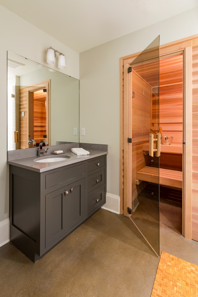 This is an example of a mid-sized transitional bathroom in Minneapolis with shaker cabinets, grey cabinets, grey walls, concrete floors, with a sauna, an undermount sink and brown floor.
