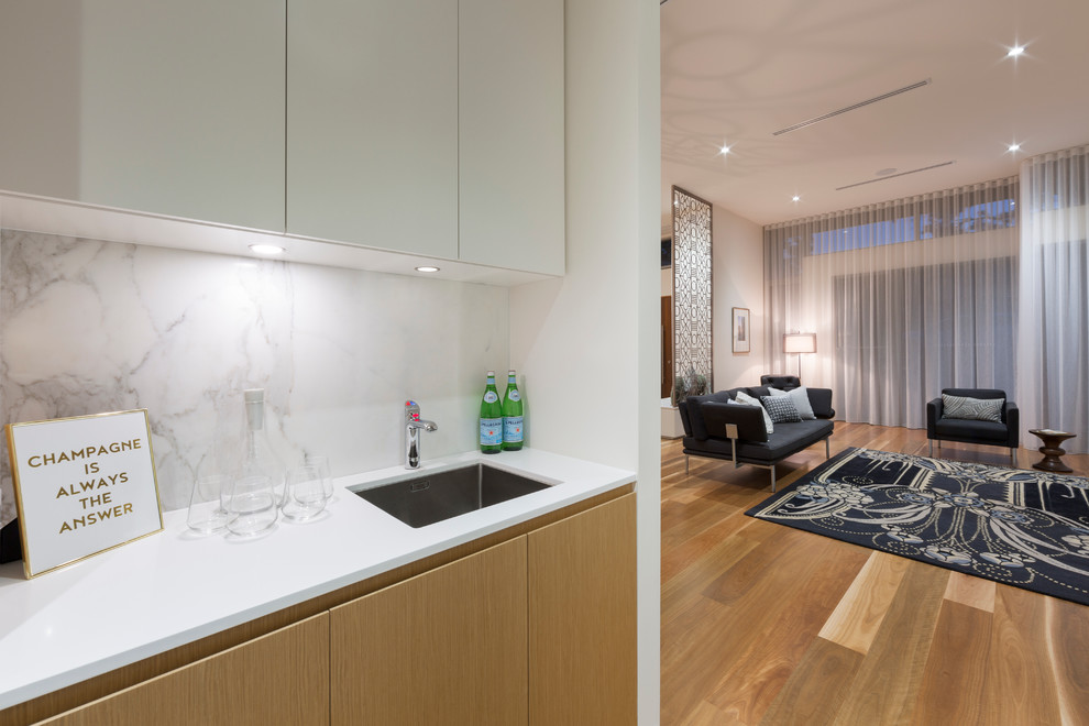 Contemporary single-wall home bar in Canberra - Queanbeyan with flat-panel cabinets, white cabinets, quartz benchtops, white splashback, stone slab splashback and medium hardwood floors.