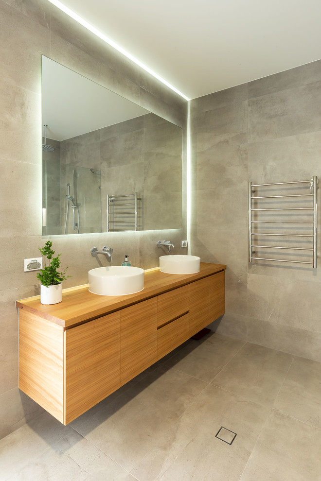 Inspiration for a large modern master bathroom in Gold Coast - Tweed with light wood cabinets, an open shower, gray tile, grey walls, wood benchtops, grey floor and an open shower.