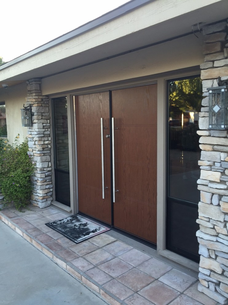 Mid-sized midcentury front door in Phoenix with terra-cotta floors, a double front door and a dark wood front door.