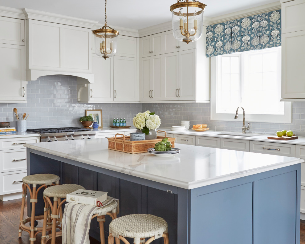 Inspiration for a traditional l-shaped kitchen in Chicago with an undermount sink, shaker cabinets, white cabinets, quartz benchtops, blue splashback, porcelain splashback, panelled appliances, medium hardwood floors, with island, brown floor and white benchtop.
