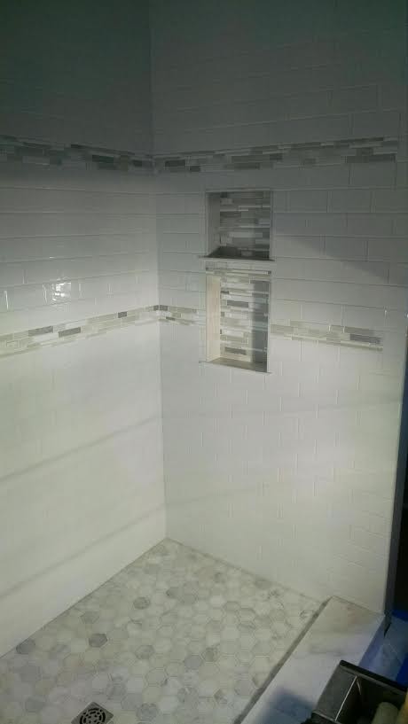 Example of a transitional white tile and subway tile marble floor alcove shower design in Milwaukee with white walls