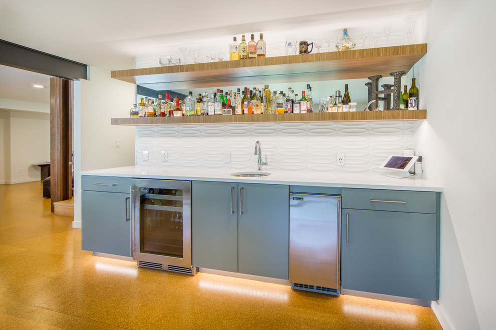 Design ideas for a mid-sized midcentury wet bar in Seattle with an undermount sink, flat-panel cabinets, blue cabinets, quartz benchtops, white splashback, ceramic splashback, cork floors and white benchtop.