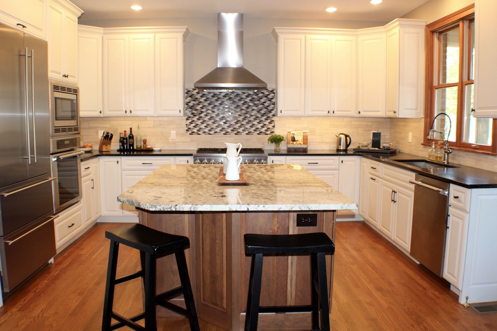 Example of a large transitional u-shaped medium tone wood floor and brown floor eat-in kitchen design in Cincinnati with a single-bowl sink, raised-panel cabinets, white cabinets, granite countertops, beige backsplash, porcelain backsplash, stainless steel appliances and an island