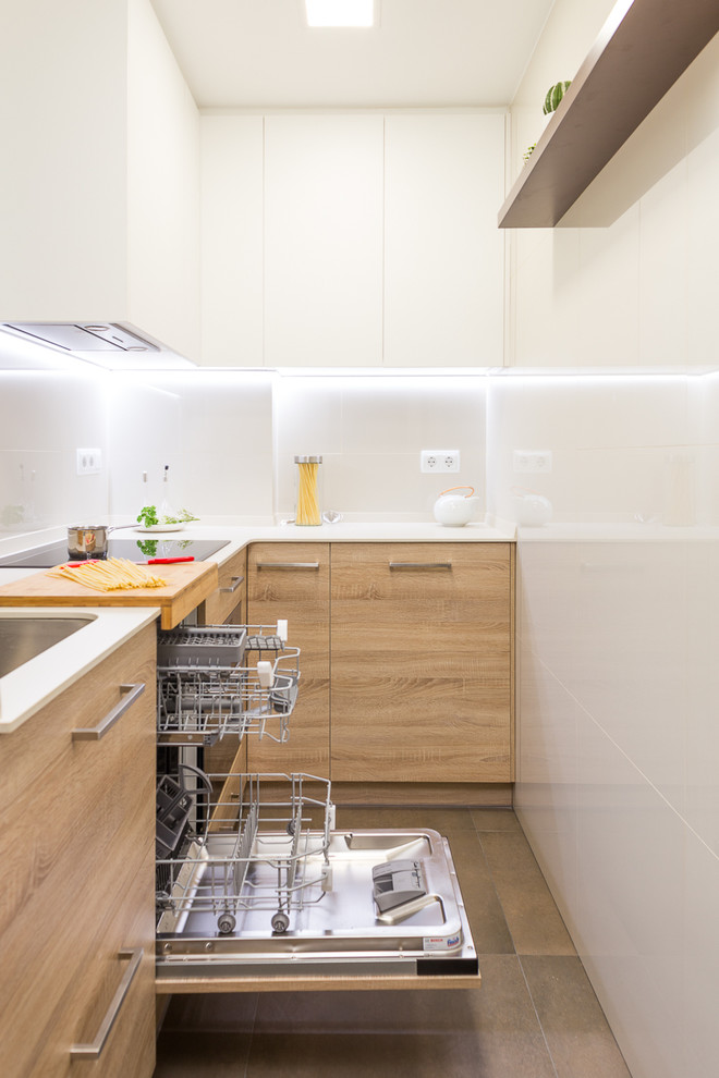 Ejemplo de cocinas en L nórdica pequeña cerrada sin isla con armarios con paneles lisos, puertas de armario de madera oscura y salpicadero blanco