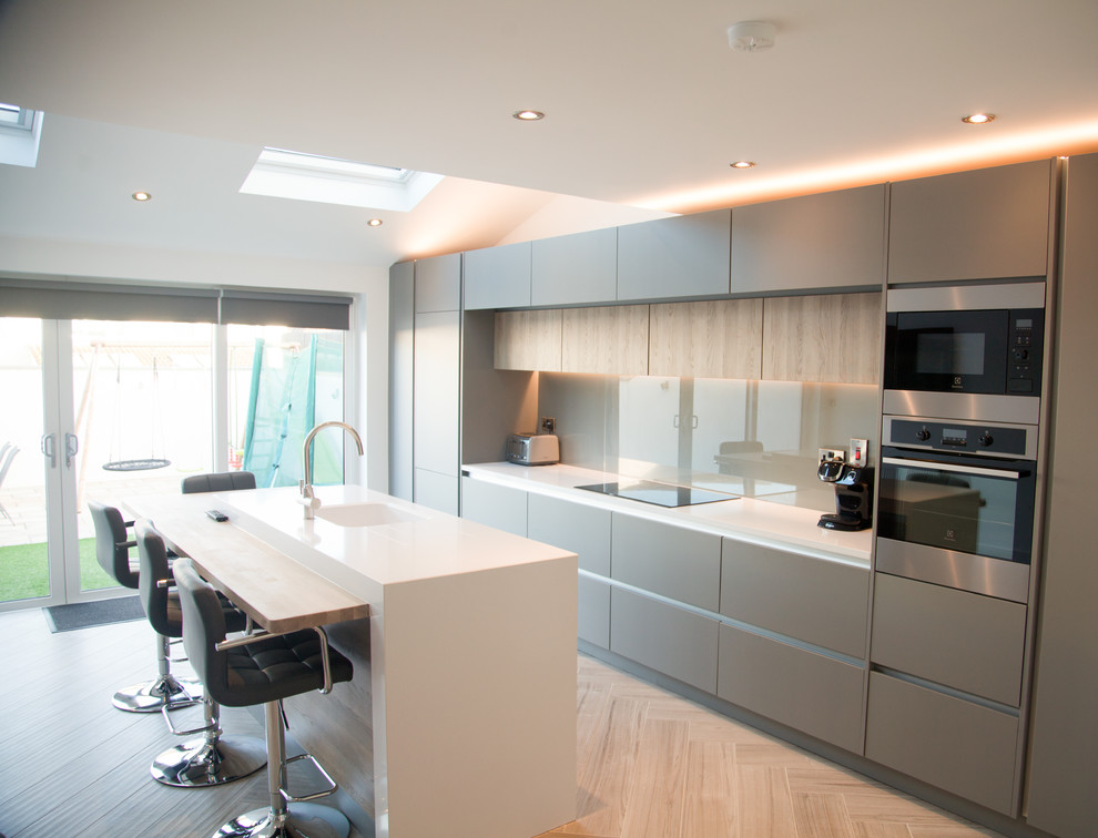Photo of a contemporary open plan kitchen in Dublin with quartzite benchtops, porcelain floors, with island and beige floor.