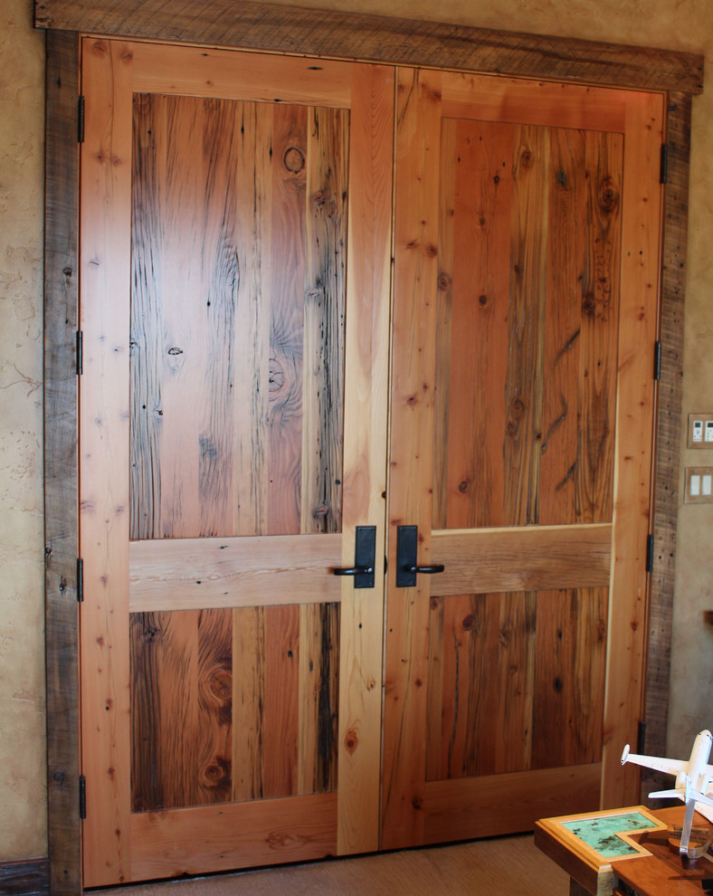 Inspiration for a large rustic home design remodel with brown walls and a medium wood front door