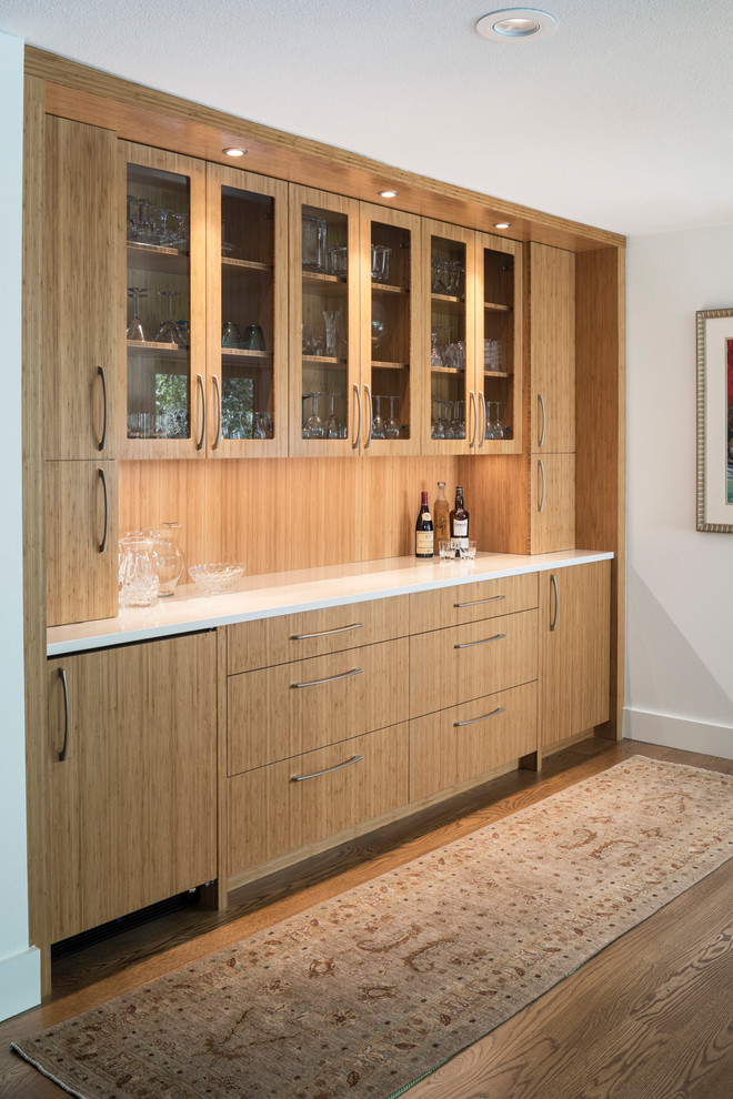 Photo of a mid-sized contemporary single-wall wet bar in Austin with glass-front cabinets, medium wood cabinets, quartzite benchtops, timber splashback and medium hardwood floors.