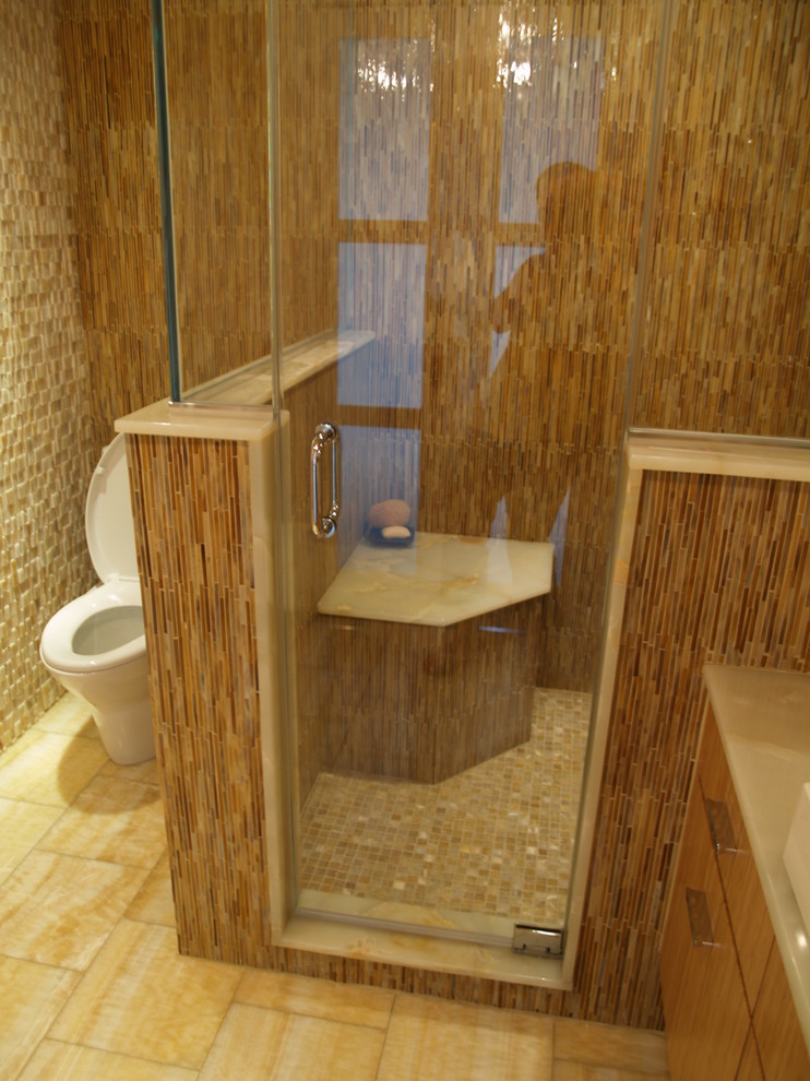 Mid-sized contemporary 3/4 bathroom in New York with flat-panel cabinets, light wood cabinets, an alcove shower, a one-piece toilet, beige tile, brown tile, white tile, matchstick tile, brown walls, porcelain floors, a vessel sink and solid surface benchtops.