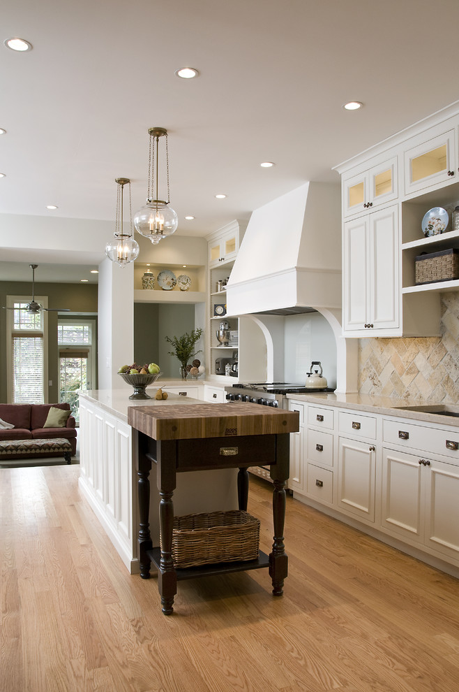 Inspiration for a mid-sized traditional single-wall eat-in kitchen in Chicago with an undermount sink, recessed-panel cabinets, white cabinets, granite benchtops, beige splashback, slate splashback, stainless steel appliances, medium hardwood floors, with island, brown floor and beige benchtop.