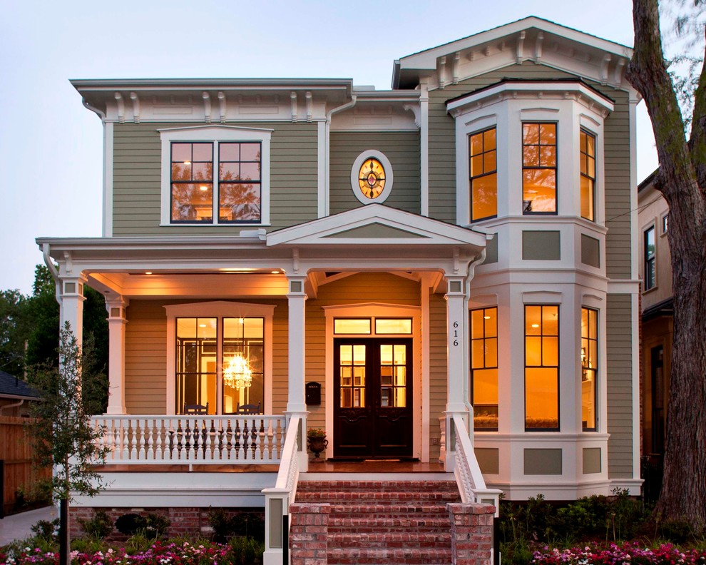 Inspiration for a mid-sized traditional two-storey green exterior in Houston with wood siding.