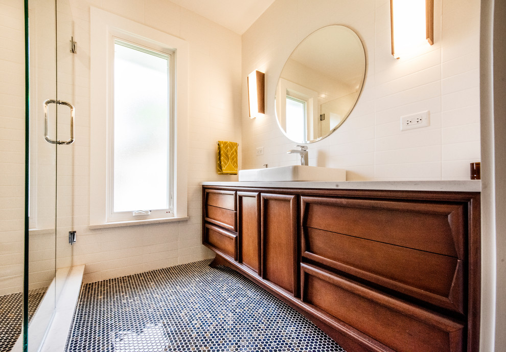 Small midcentury master bathroom in Chicago with furniture-like cabinets, dark wood cabinets, an alcove shower, a wall-mount toilet, white tile, subway tile, white walls, mosaic tile floors, a vessel sink, engineered quartz benchtops, blue floor, a hinged shower door and white benchtops.