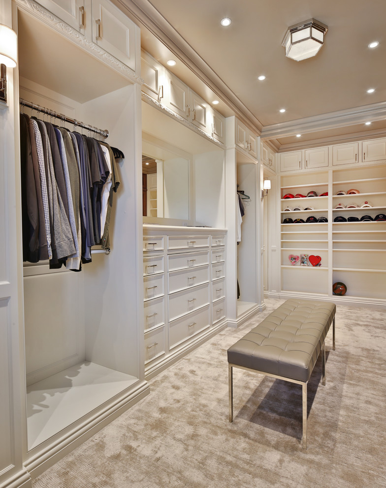 This is an example of a large traditional women's walk-in wardrobe in Columbus with beaded inset cabinets, white cabinets, carpet and grey floor.