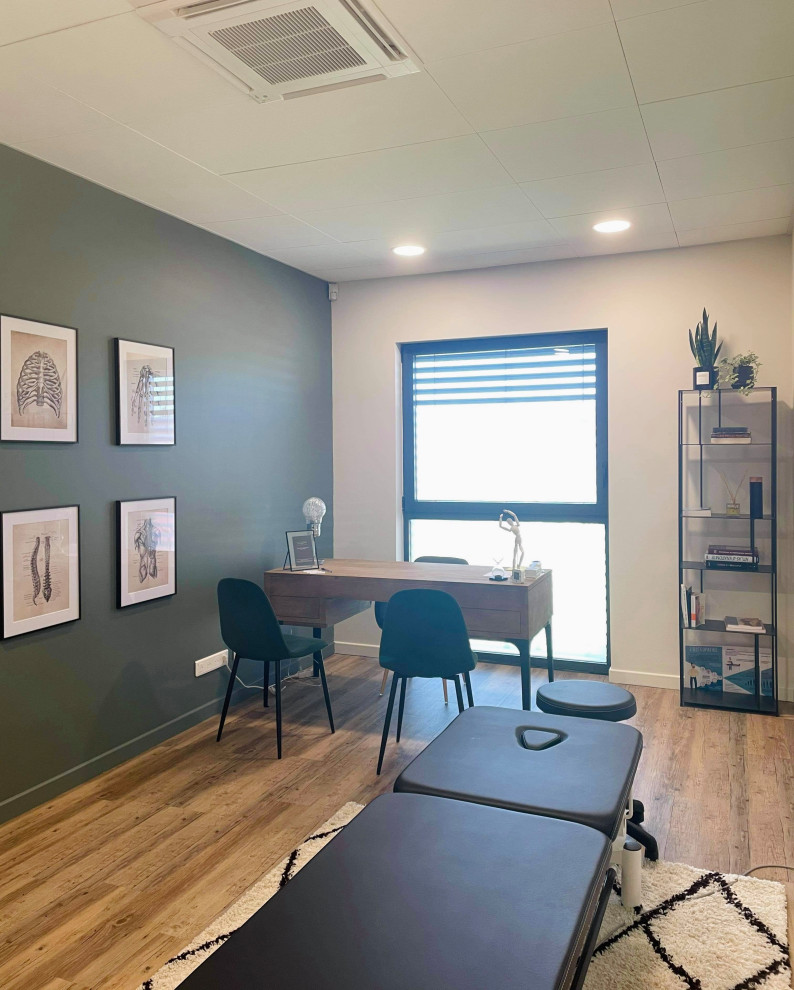 Medium sized contemporary study in Lyon with green walls, light hardwood flooring, no fireplace, a freestanding desk and brown floors.