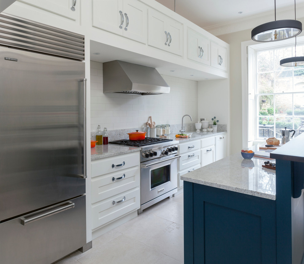 Inspiration for a mid-sized transitional single-wall kitchen in Wiltshire with stainless steel appliances, with island, an undermount sink, shaker cabinets, white cabinets, white splashback and subway tile splashback.