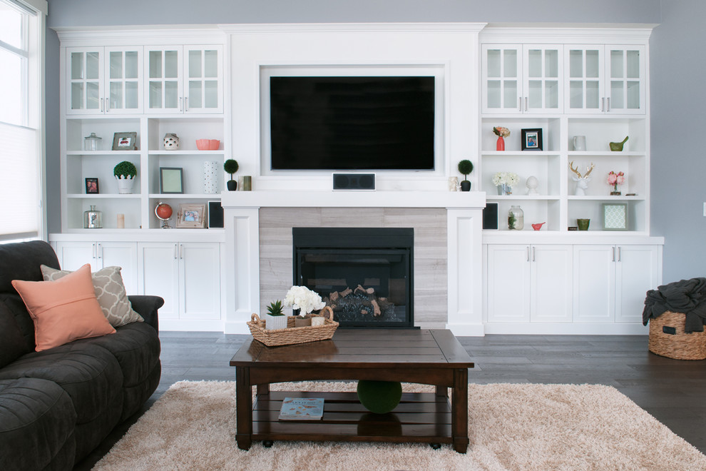 Inspiration for a large transitional open concept living room in Vancouver with grey walls, dark hardwood floors, a standard fireplace, a tile fireplace surround and a built-in media wall.
