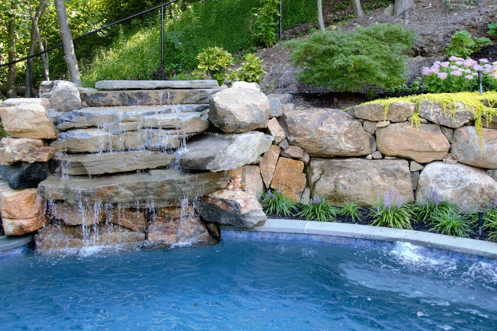 Inspiration for a small country backyard kidney-shaped natural pool in New York with a water feature and natural stone pavers.
