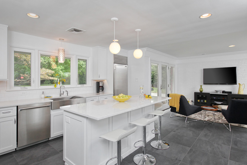 Inspiration for a mid-sized transitional l-shaped open plan kitchen in Philadelphia with a farmhouse sink, shaker cabinets, white cabinets, marble benchtops, white splashback, subway tile splashback, stainless steel appliances, slate floors and with island.