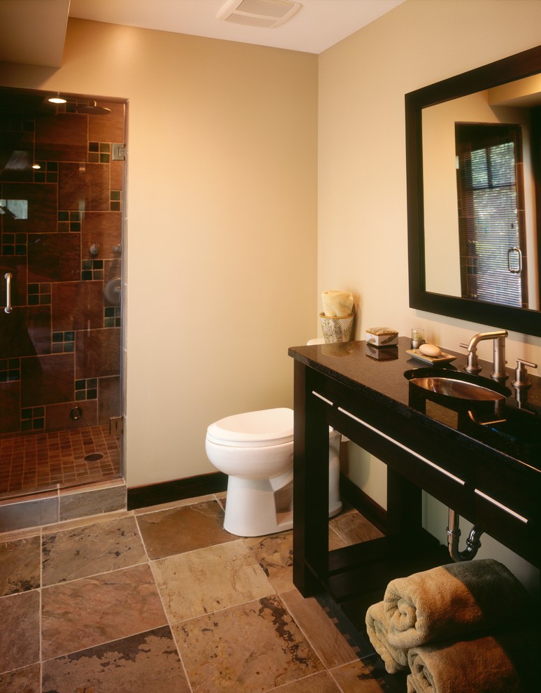 Photo of a traditional bathroom in Minneapolis with an undermount sink, furniture-like cabinets, dark wood cabinets, multi-coloured tile, stone tile, limestone floors and beige walls.