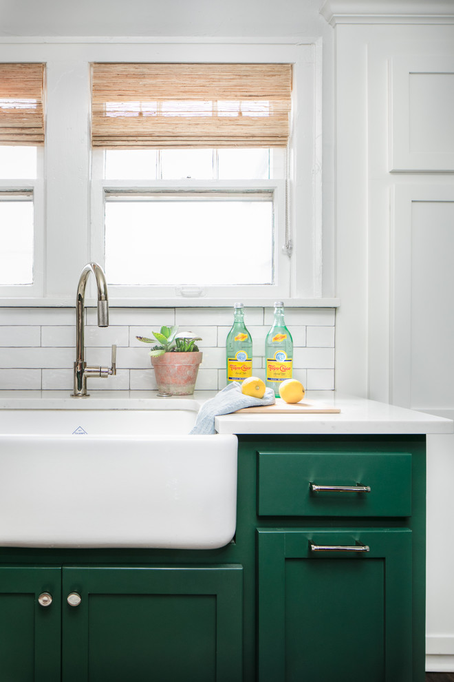 Kitchen - mid-sized transitional medium tone wood floor and brown floor kitchen idea in Chicago with a farmhouse sink, shaker cabinets, green cabinets, quartz countertops, white backsplash, subway tile backsplash, stainless steel appliances, an island and white countertops