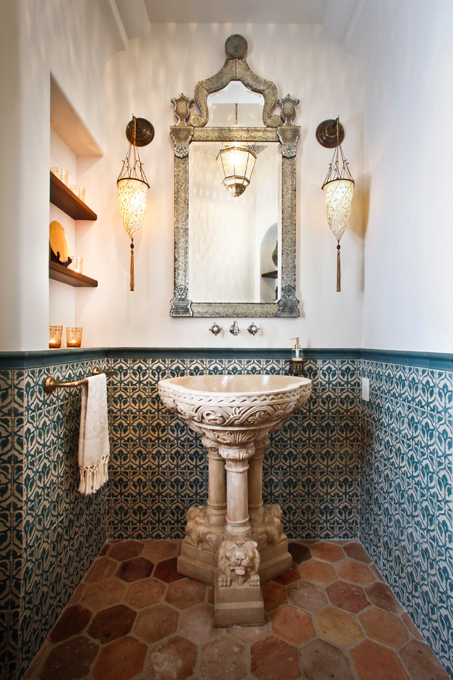 Inspiration for a mid-sized mediterranean powder room in Los Angeles with green tile, ceramic tile, white walls, terra-cotta floors, a pedestal sink and multi-coloured floor.