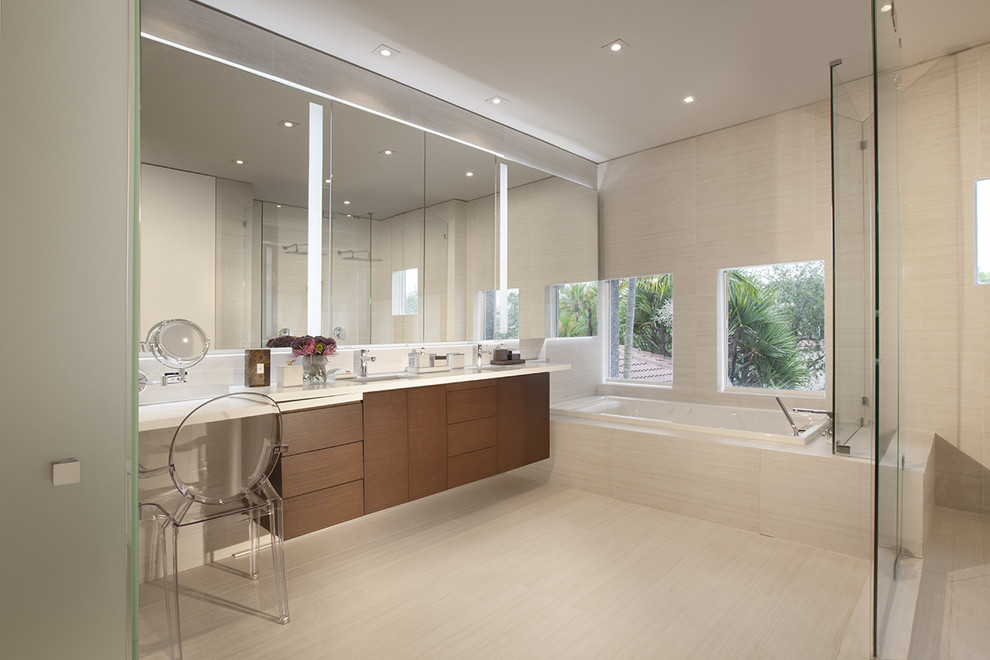 Inspiration for a contemporary master bathroom in Miami with flat-panel cabinets, dark wood cabinets, a drop-in tub, a corner shower and beige tile.