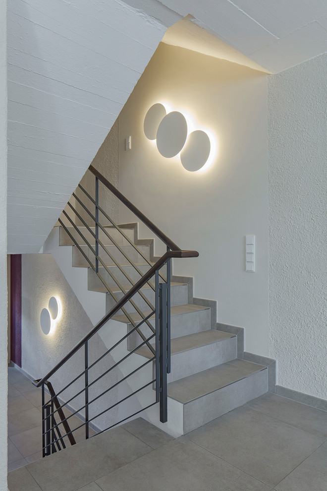 Kleine Moderne Treppe in U-Form mit gefliesten Treppenstufen, gefliesten Setzstufen und Mix-Geländer in München
