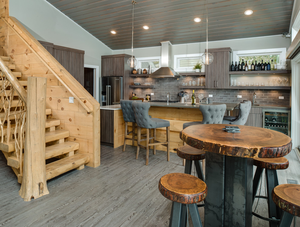 Mid-sized mountain style galley light wood floor and gray floor eat-in kitchen photo with an undermount sink, flat-panel cabinets, gray cabinets, quartz countertops, gray backsplash, subway tile backsplash, stainless steel appliances, an island and gray countertops