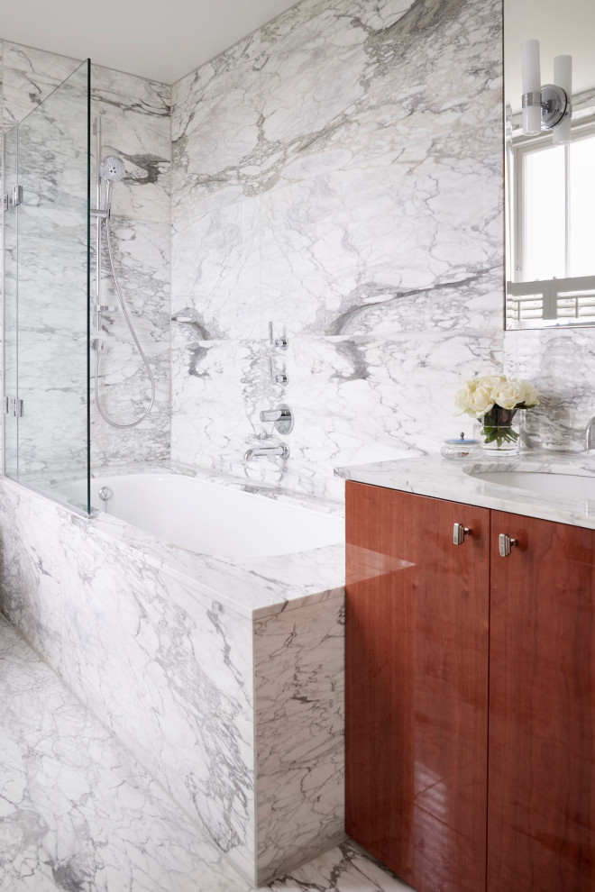 Inredning av ett klassiskt mellanstort vit vitt en-suite badrum, med släta luckor, skåp i mörkt trä, ett platsbyggt badkar, en dusch/badkar-kombination, vit kakel, marmorkakel, marmorgolv, ett integrerad handfat och marmorbänkskiva