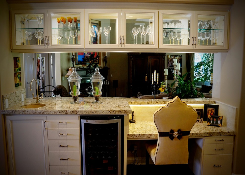 This is an example of a large transitional galley home bar in Sacramento with an undermount sink, recessed-panel cabinets, white cabinets, granite benchtops, beige splashback, subway tile splashback and concrete floors.