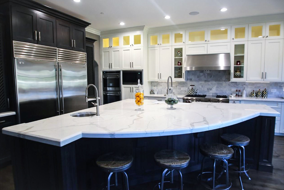 Design ideas for a large contemporary l-shaped kitchen in Orange County with an undermount sink, shaker cabinets, white cabinets, marble benchtops, grey splashback, stainless steel appliances, medium hardwood floors, with island, brown floor and white benchtop.