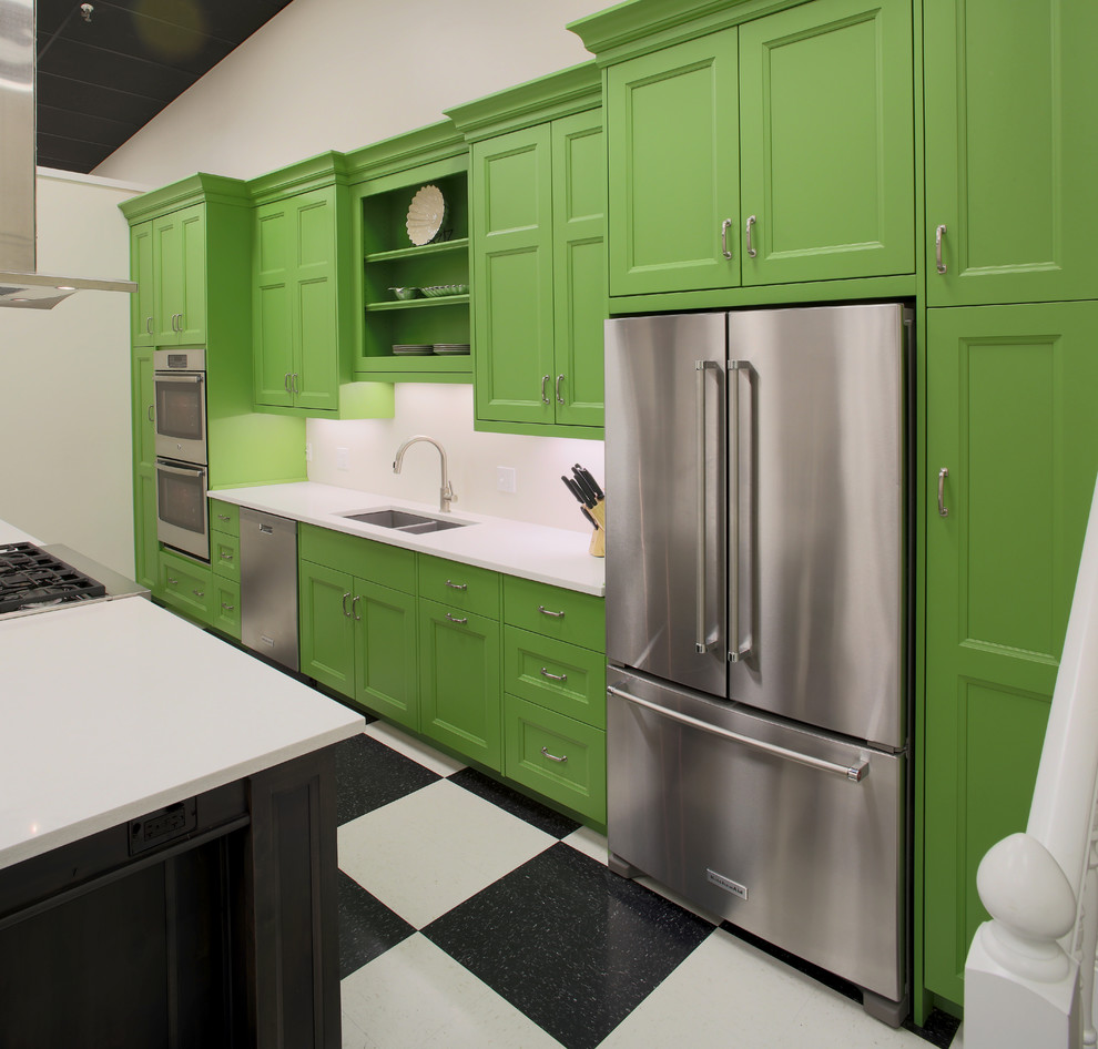 Example of a mid-sized transitional galley open concept kitchen design with an undermount sink, recessed-panel cabinets, green cabinets, quartz countertops, stainless steel appliances and an island