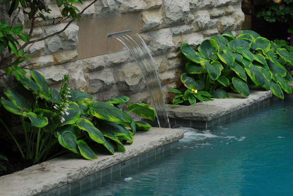 Inspiration for a mid-sized traditional backyard partial sun garden for summer in Toronto with a water feature and natural stone pavers.