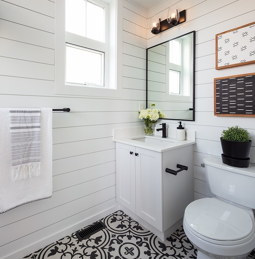 This is an example of a small country bathroom in Vancouver with shaker cabinets, white cabinets, a two-piece toilet, white walls, cement tiles, an undermount sink, quartzite benchtops, black floor and white benchtops.
