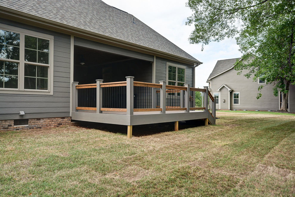 Inspiration for a large craftsman backyard deck remodel with a roof extension