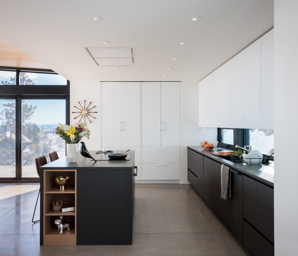 Foto di una cucina moderna di medie dimensioni con ante lisce, ante grigie, top in quarzo composito, paraspruzzi a finestra, pavimento in cemento e top grigio