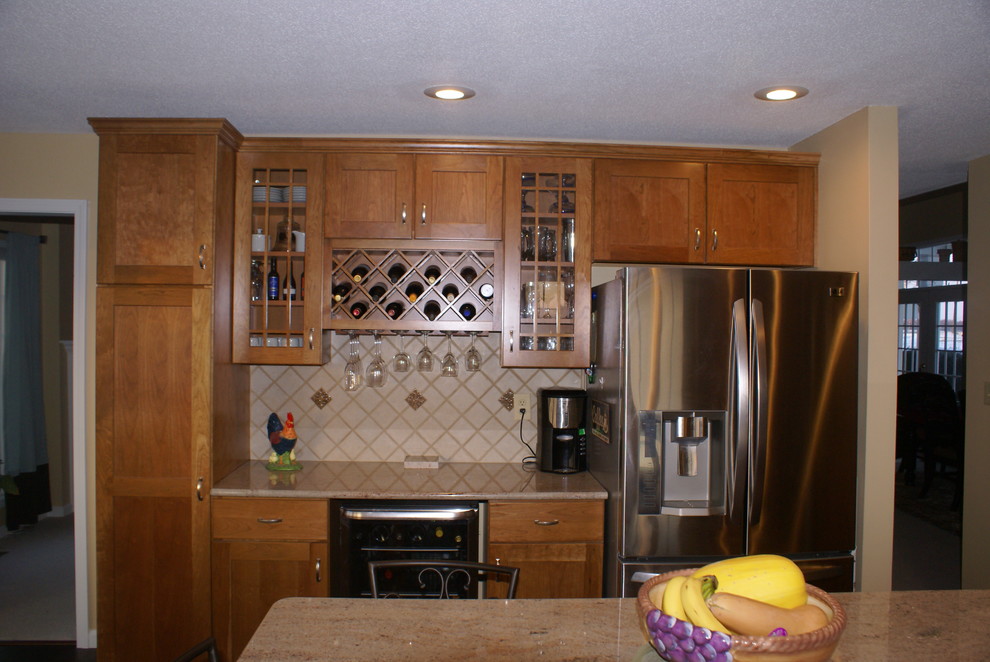 Eat-in kitchen - transitional l-shaped eat-in kitchen idea in Indianapolis with an undermount sink, recessed-panel cabinets, light wood cabinets, granite countertops and stainless steel appliances