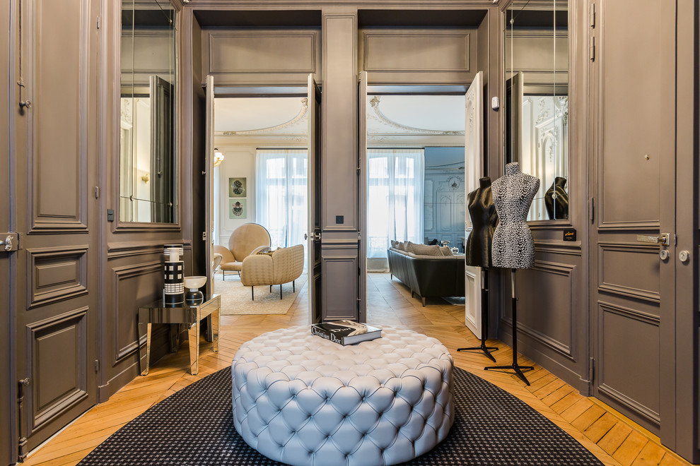 This is an example of a mid-sized transitional vestibule in Paris with grey walls, medium hardwood floors and a gray front door.