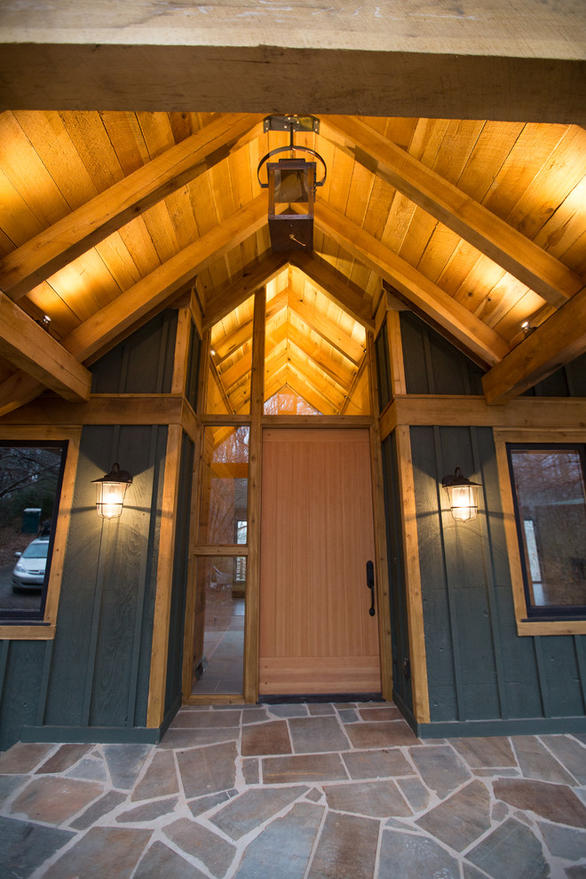 Large mountain style concrete floor front door photo with blue walls and a medium wood front door